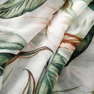 Close-up of tropical palm leaf print on lightweight cotton linen fabric with tassel details