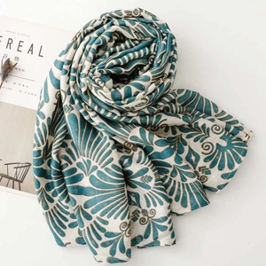 Close-up of lightweight linen scarf with blue geometric floral prints and frayed edges