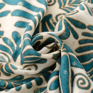 Close-up of linen-feel scarf fabric featuring blue leaf patterns and gold foil details