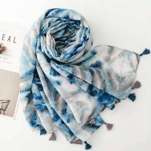 Detail of blue and white tie-dye scarf with soft fringe and marble pattern texture