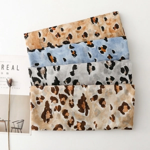 Detail showing four assorted leopard print scarves in earth and pastel tones