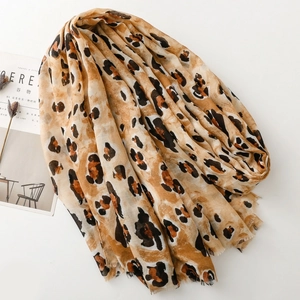 Detail of leopard print scarf with soft fringe edges and golden rock texture finish