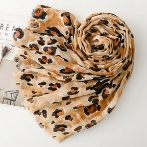 Detail of leopard print scarf folded into a heart shape on a white minimalist background