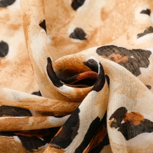 Detail of soft leopard print scarf showing linen-feel texture and gold foil rock patterns