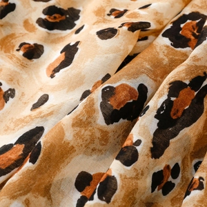 Close-up of lightweight leopard print fabric with gold foil accents and soft texture