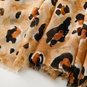 Detailed close-up of leopard print scarf featuring cotton-linen texture and fringe edges