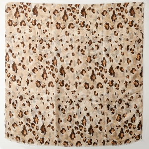 Close-up of leopard print scarf with soft fringe edges and light cotton linen texture