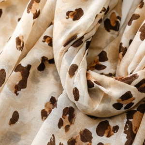 Close-up of leopard print scarf showing soft cotton-linen texture and gold foil details