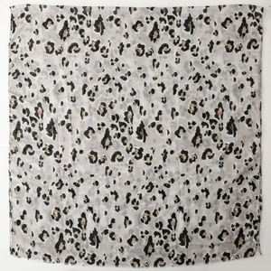 Macro view of leopard print cotton-linen scarf with golden foil rock patterns and frayed edges