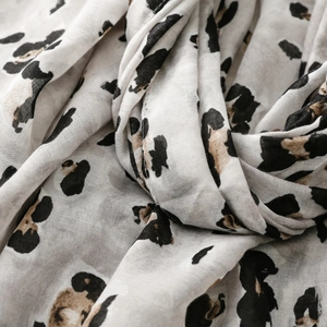 Macro detail of breathable cotton-linen scarf featuring golden foil and leopard patterns