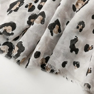 Close-up of leopard print cotton-linen scarf featuring frayed edges and soft texture