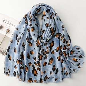 Light blue leopard print scarf with gold accents and frayed edges on a clean background