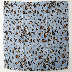 Detailed view of light blue leopard print scarf with soft linen-feel fabric and gold foil