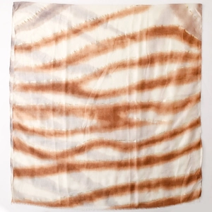 Détail de l'écharpe en coton et lin avec accents dorés et bords effilochés fins
