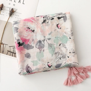 Detail of pink floral linen scarf featuring delicate fringe and soft textured fabric