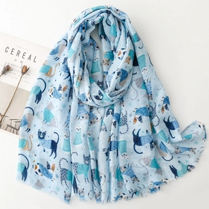 Detail of light blue cotton scarf featuring cute cat print and winter snowflakes pattern