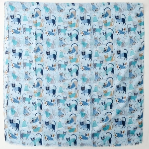 Detailed view of the cute cartoon cat pattern printed on the blue silk scarf fabric