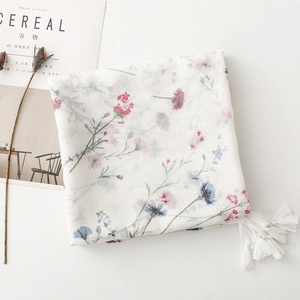 Detail of white floral print scarf with soft fringe and elegant botanic patterns