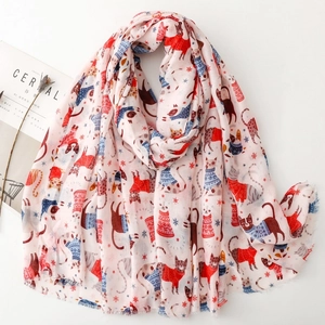 Pink scarf featuring cartoon cats and snowflakes laid next to a Cereal magazine