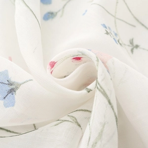 Macro detail of breathable white floral scarf fabric with fine weave and soft drape