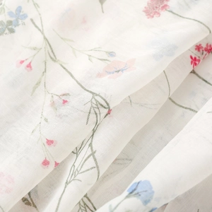 Close-up of white floral bali yarn scarf fabric with delicate pink and blue flower prints