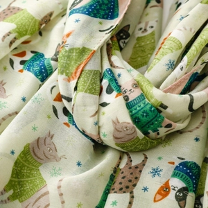 Close-up of soft cotton scarf fabric with cartoon cat patterns and snowflake prints