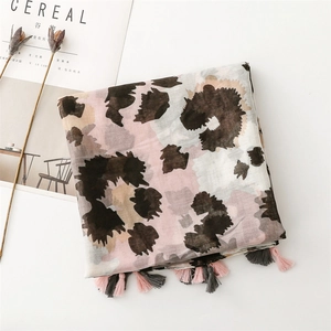 Close-up of lightweight leopard print scarf featuring pink fringe and breathable fabric