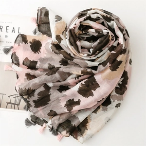 Detail of soft leopard print scarf with pink fringe tassels on minimalist background
