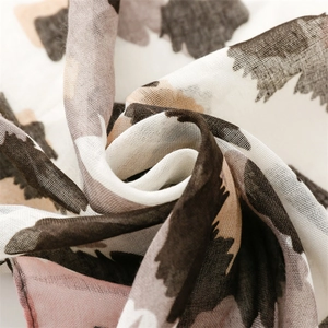 Macro shot of breathable leopard print voile scarf showing soft texture and tassel details