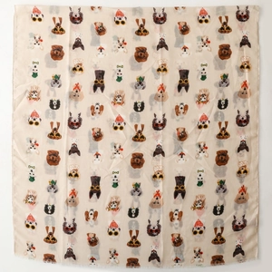 Close-up of lightweight beige scarf featuring repeating cartoon dog patterns and sunglasses