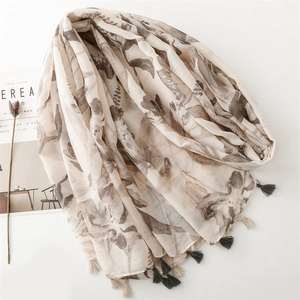 Linen feel cotton scarf with brown leaf print and tassel trim on white background