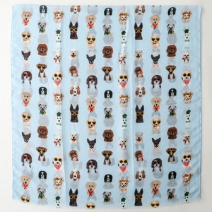 Detail of light blue silk scarf featuring colorful dog prints and sunglasses patterns