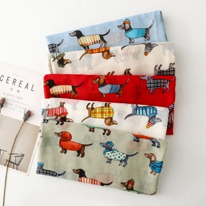 Close-up of assorted colorful dachshund print scarves neatly folded on a white surface