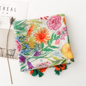 Detail of floral voile scarf featuring vibrant flower prints and colorful tassels