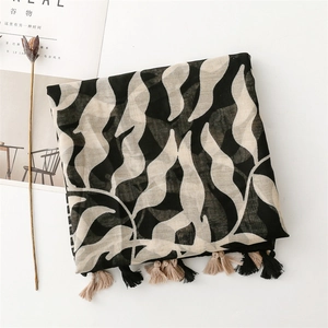 Detail of floral print scarf with elegant tassels and leaf patterns on a white background