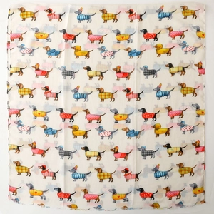 Detailed pattern of cute dachshunds in colorful sweaters on a cream satin scarf