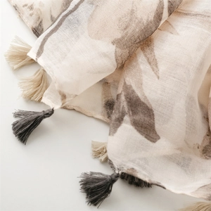 Close-up of lightweight linen-feel scarf with botanical print and bicolor tassels