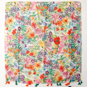 Lightweight floral voile scarf with vibrant blossoms and colorful tassels on white