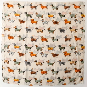 Detail of dachshund print scarf showing repeated dog patterns with colorful sweaters