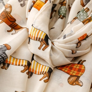 Close-up of soft beige satin cotton scarf with cute cartoon dachshund dog patterns
