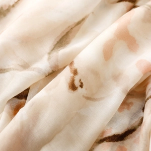 Detailed macro shot of ink-painting style floral pattern on soft silk satin scarf fabric