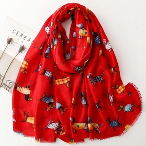 Detail of red scarf with cartoon dachshund print and soft fringe edges on white background