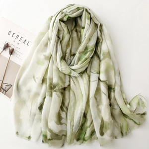 Detail of green ink wash floral scarf with soft fringe edges and lightweight texture