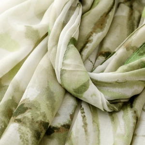 Detailed texture of white silk scarf with green watercolor ink print and soft folds