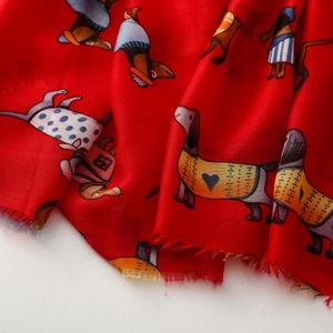 Detail of red scarf with cartoon dachshund prints and soft tassel edges for spring