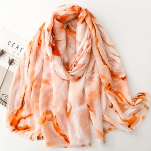 Artistic marble print silk scarf with orange and beige patterns and fringe edges