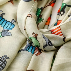 Detail of light green scarf showing woven texture and colorful dachshund dog prints