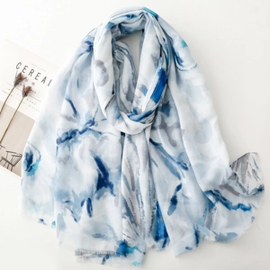 Detail of blue ink-style floral print on long scarf with fringe and aesthetic props