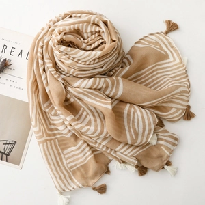 Detailed view of the khaki and white irregular striped cotton linen scarf with soft tassels