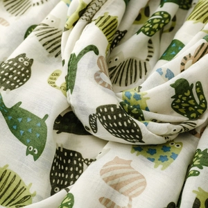 Detail of soft cotton scarf fabric showing cute cartoon cat print and woven texture